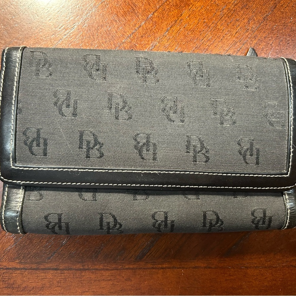 Dooney & Bourke Black Logo Fold Wallet It has a small detail on the inside
